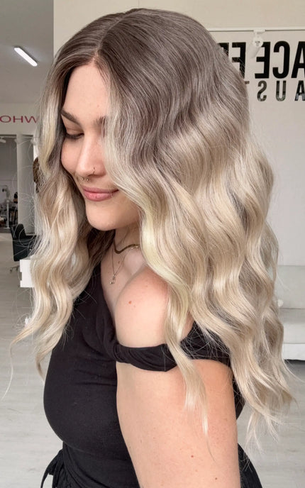 right side view showing beachy waves and a soft blended ombre of dar cool toned blonde to lighter blonde