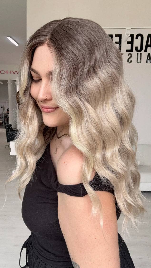 right side view showing beachy waves and a soft blended ombre of dar cool toned blonde to lighter blonde