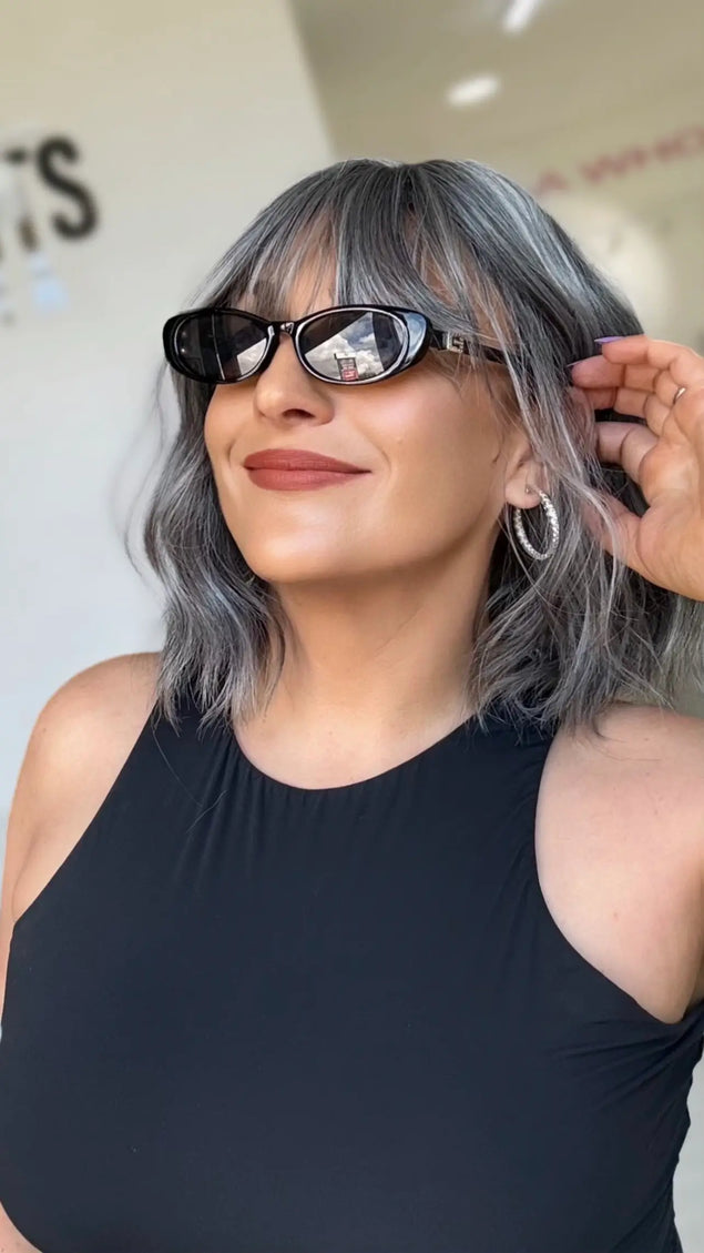 right side view tucking grey silver hair behind ears, fringe and middle part, with heat safe synthetic hair for easy styling up to 180 degrees celcius.