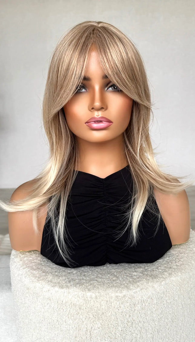 synthetic topper sandy blonde hair, middle part with curtain bangs.