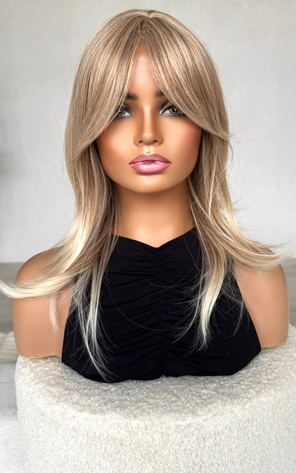 synthetic topper sandy blonde hair, middle part with curtain bangs.