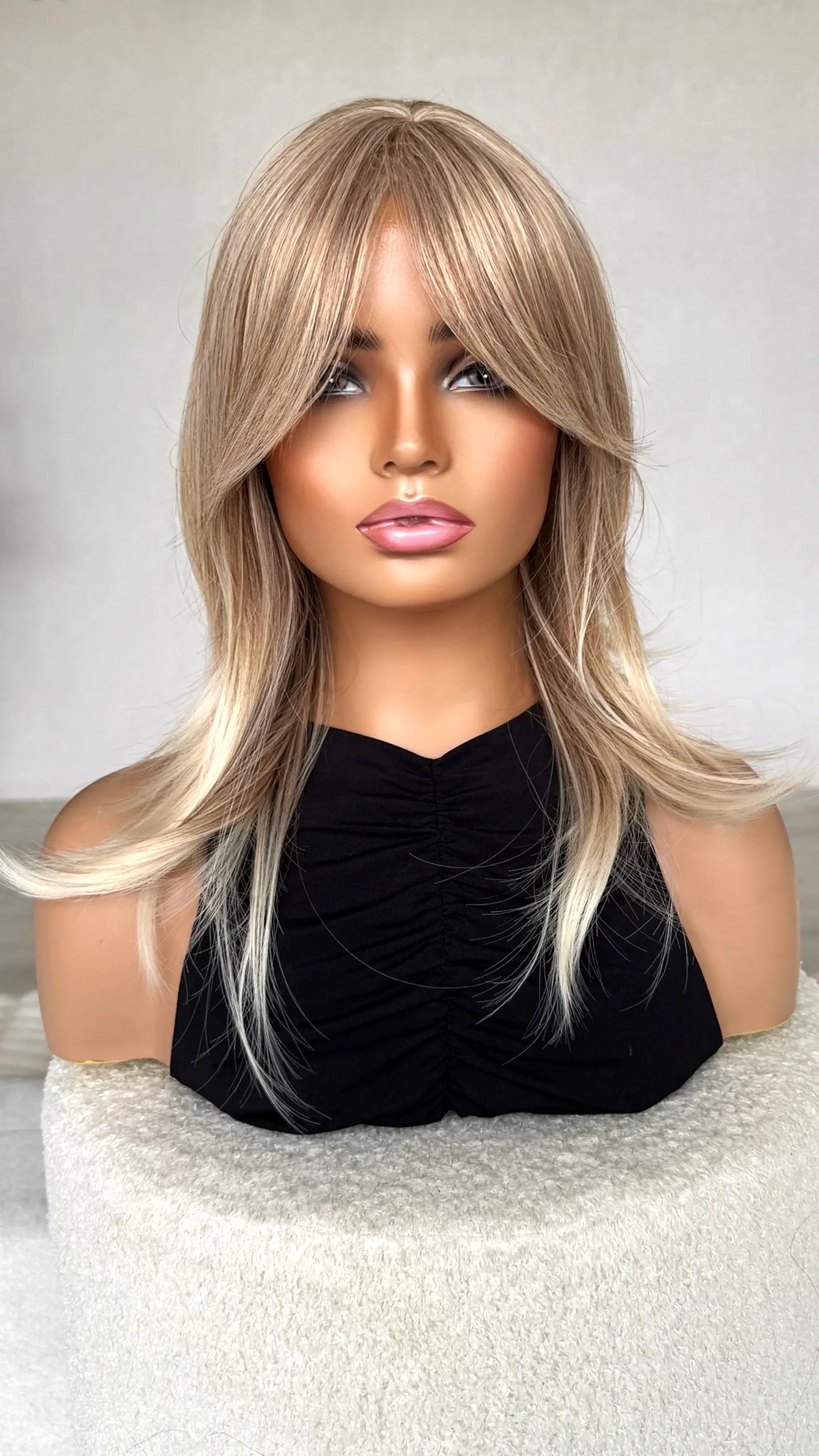 synthetic topper sandy blonde hair, middle part with curtain bangs.