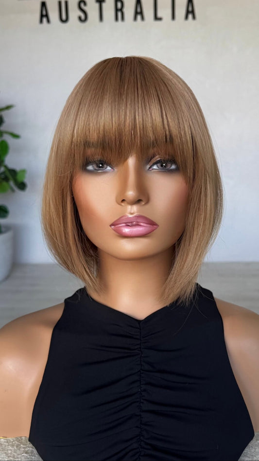 front view of strawberry blonde synthetic wig, bob cut with fringe.