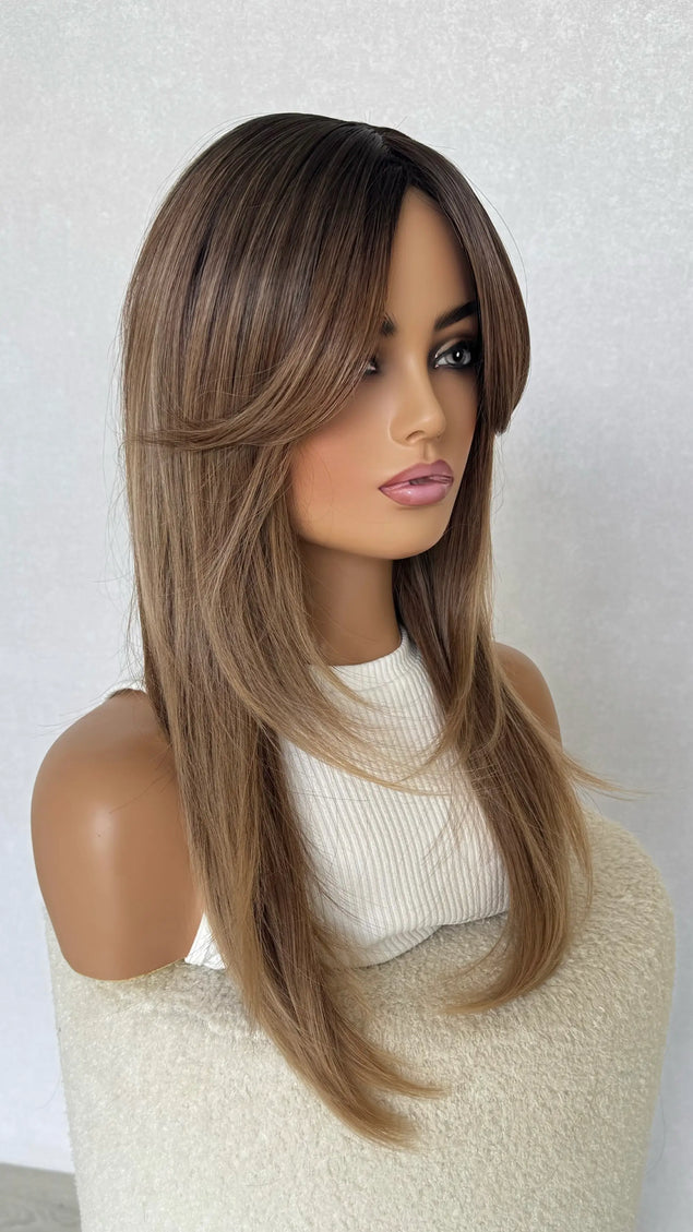 layered synthetic wig with layers and curtain bangs.