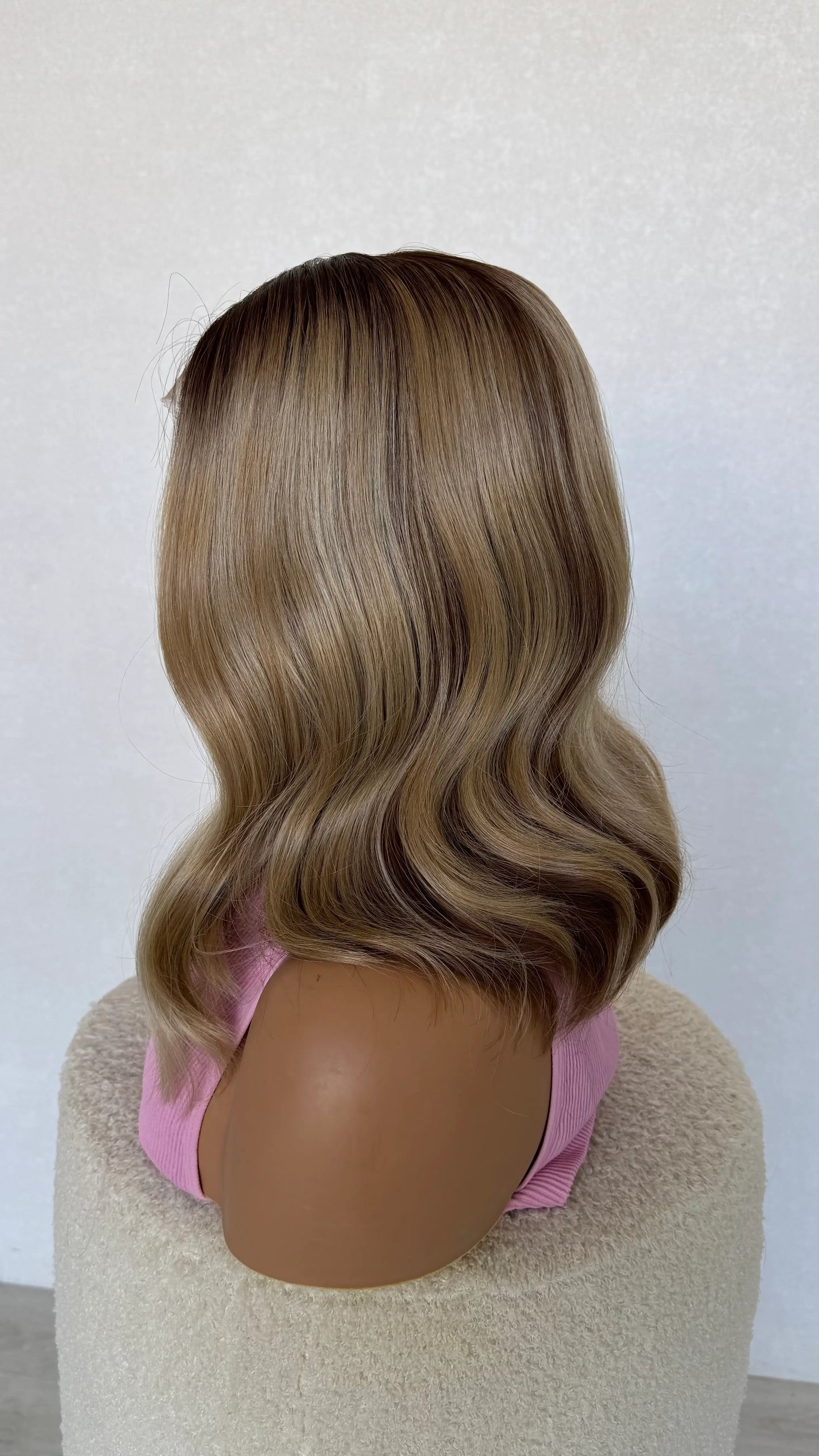 blake synthetic wig from side on view, mixed colouring through hair, brunette and warm blonde tones.