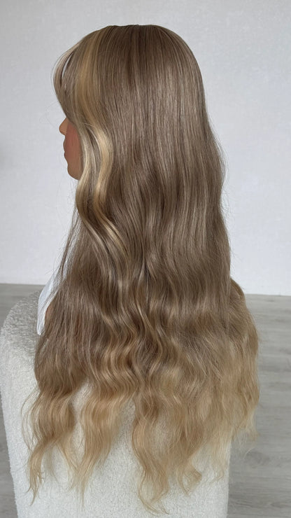 siude view showing long blonde hair, slight wave with lighter ends, heat safe synthetic hair.