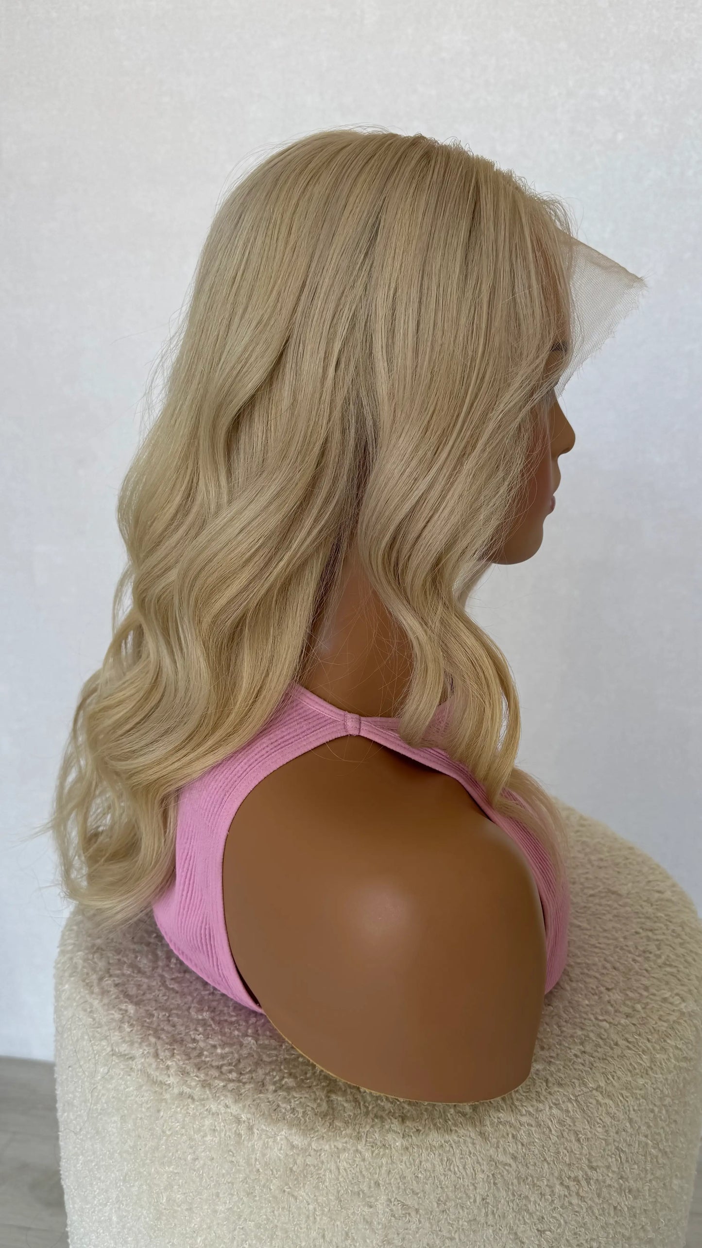 human hair lacefront wig side on view, with wavy styling. golden undertones.