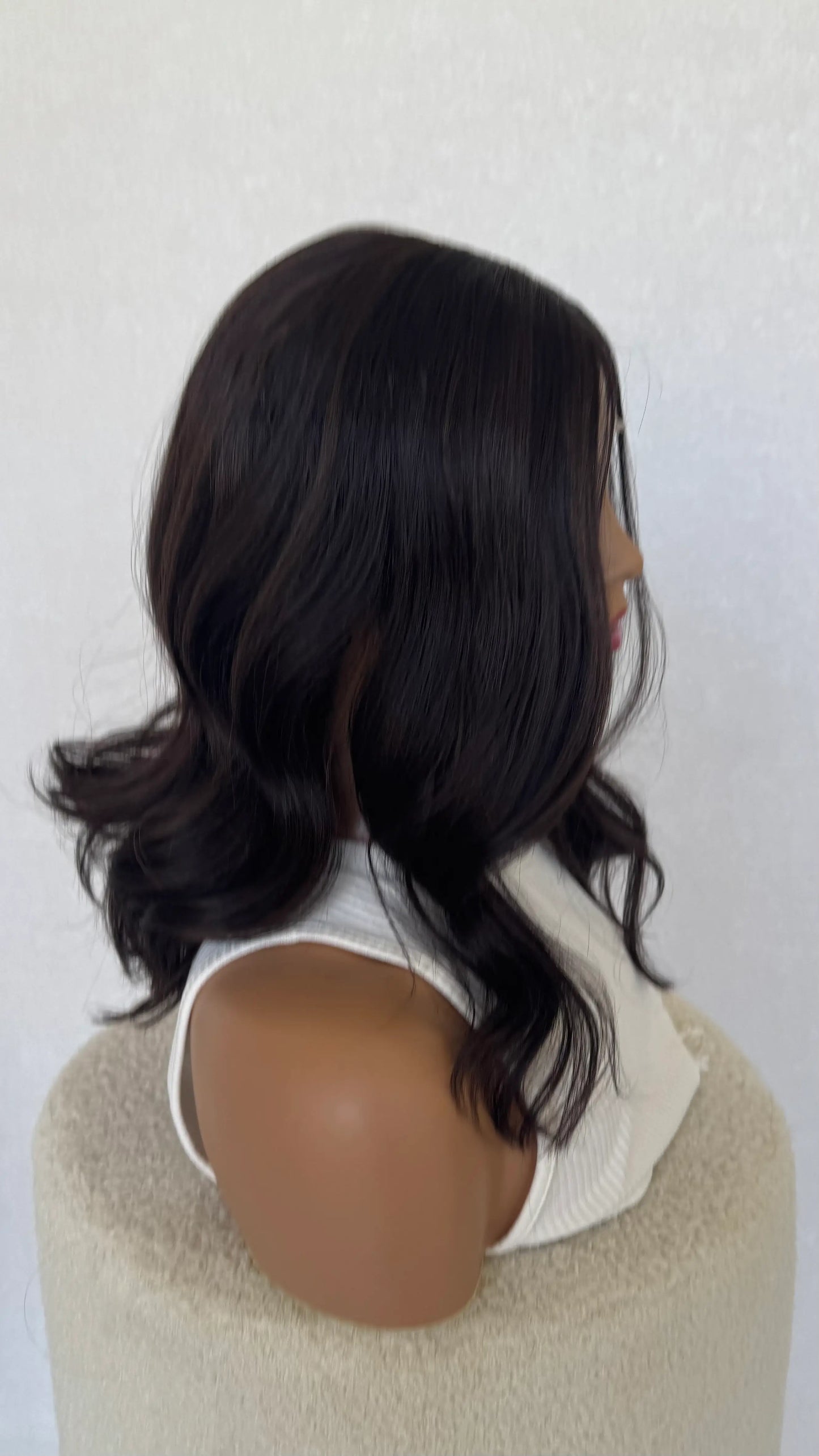 side on view, dark brunette lace front, wavy hair.