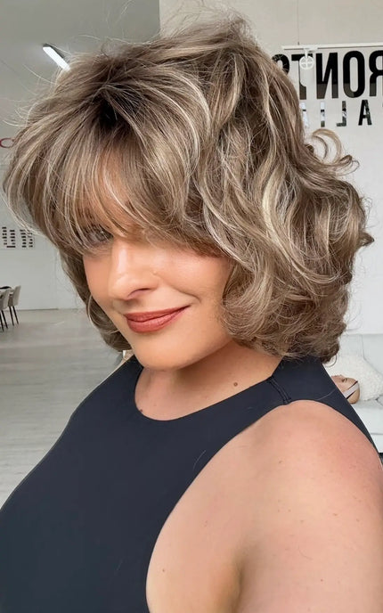side view showing heavily layered light brunette bob length hair with highlights.