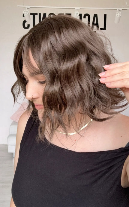 a side view showing the wavy styling on the short length bob synthetic, length just shorter than shoulder length.
