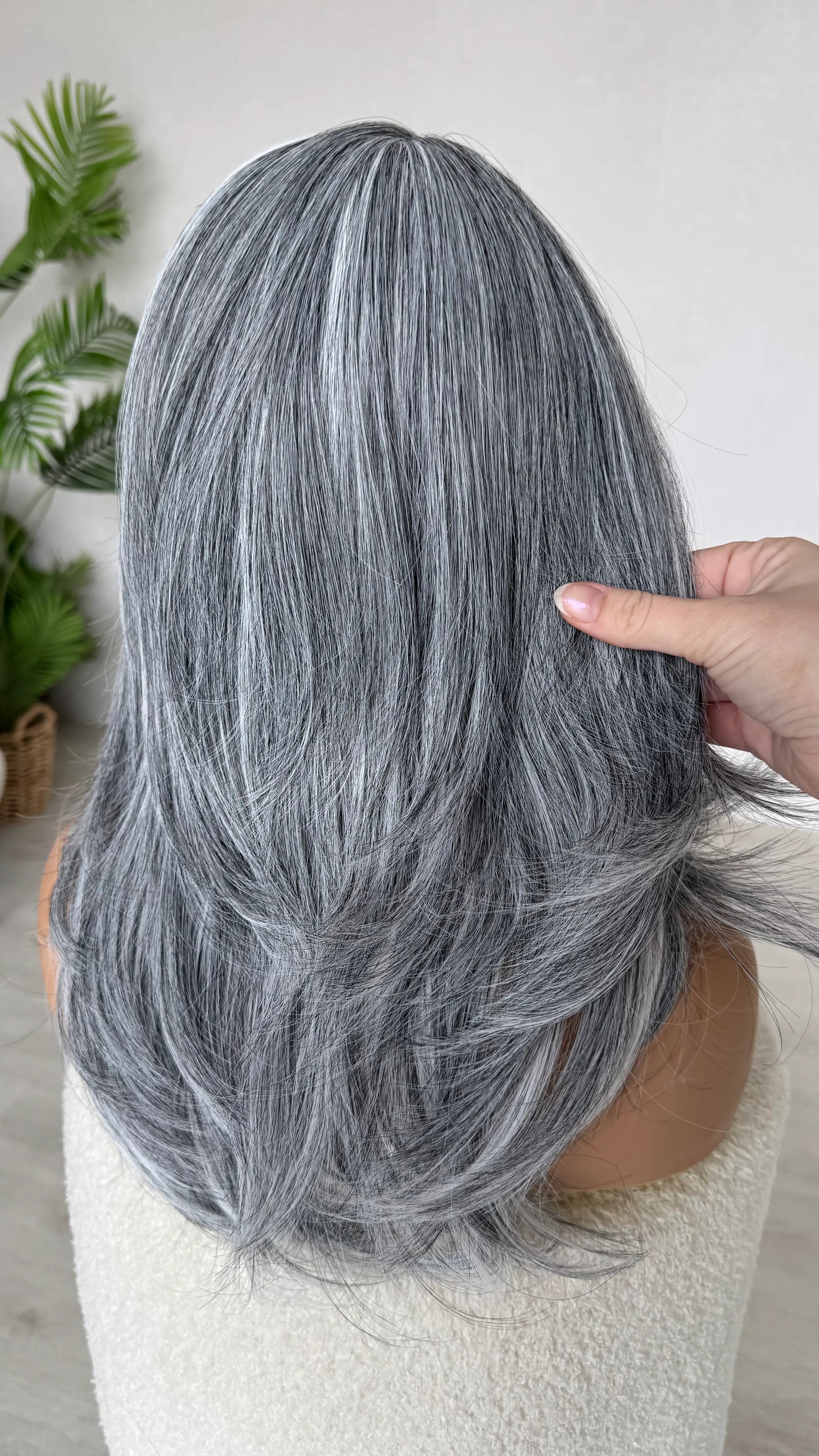 back view holding salt and pepper grey wig hair, heat safe fibers