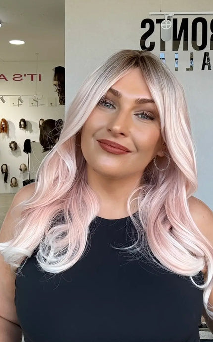 soft pastel pink hair with long curtain bang layers, a middle part and a light curl throughout. heat safe hair that can be changed with styling.