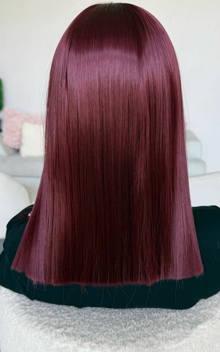 a natural looking heat safe synthetic wig in a deep red colour.
