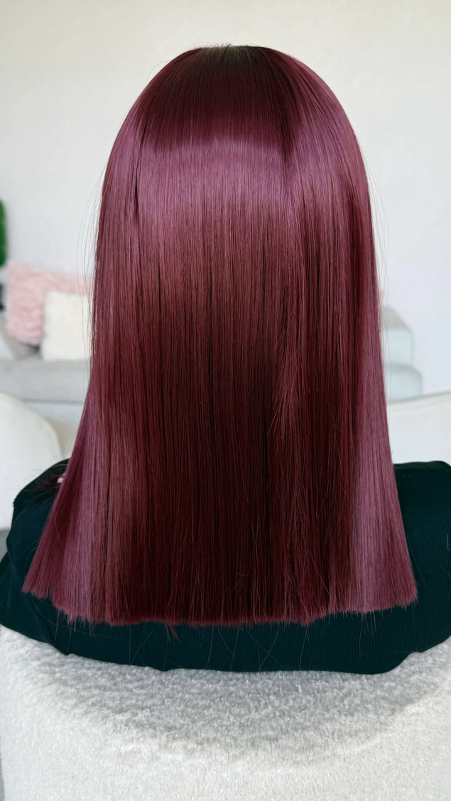 a natural looking heat safe synthetic wig in a deep red colour.
