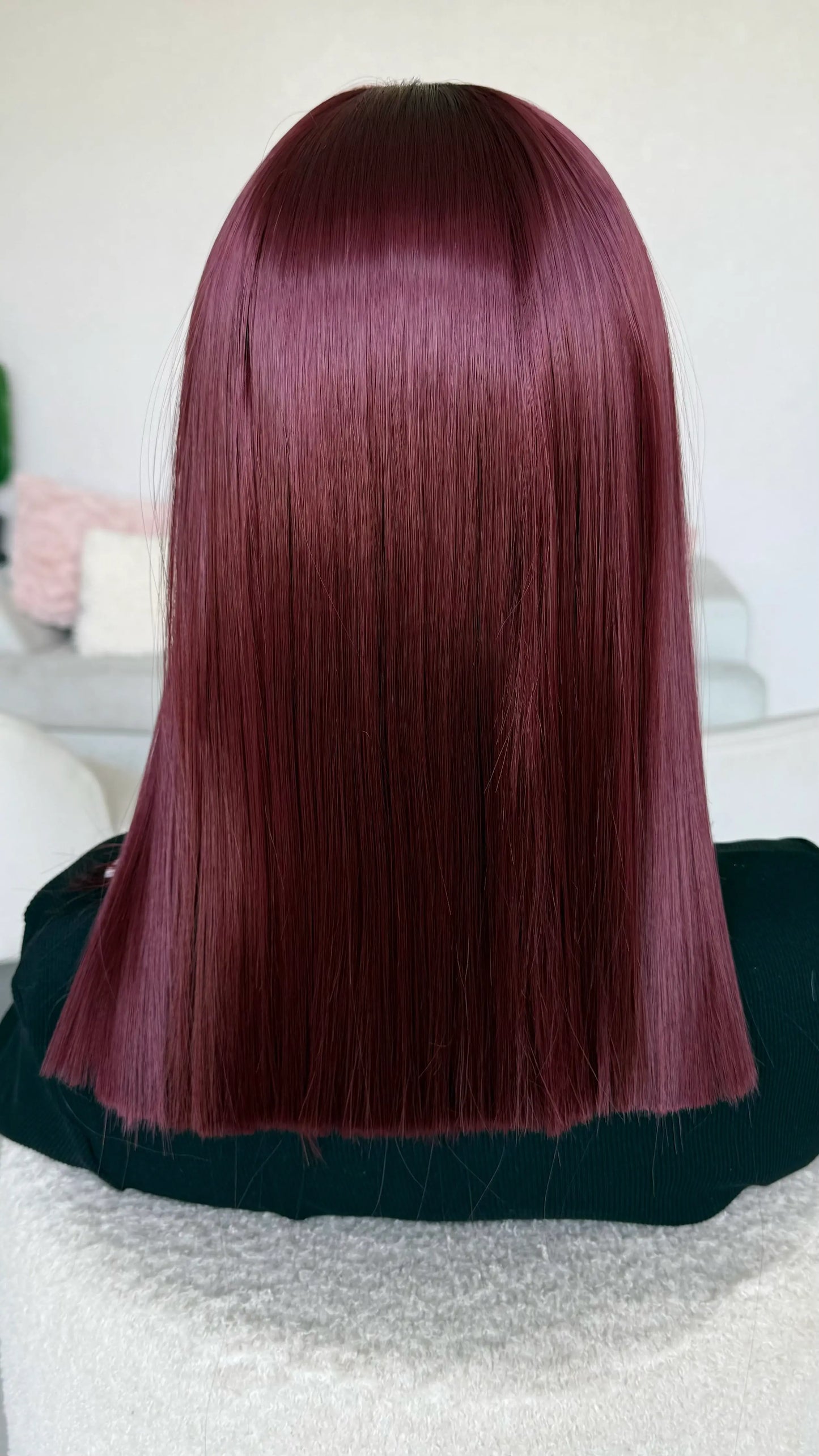 a natural looking heat safe synthetic wig in a deep red colour.