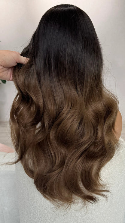 back view of holding the wavy hair. showing soft blend of dark to ligh brown hair. heat safe hair.