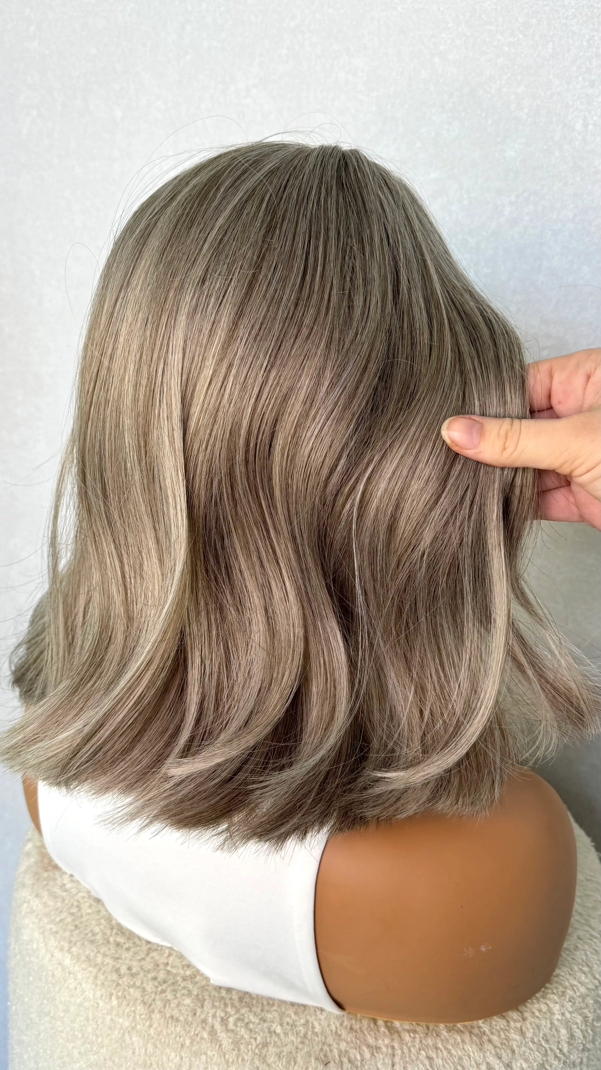 synthetic wig from the back. showing grey/ silver hair colour in natural lighting. 14 inch length of hair.