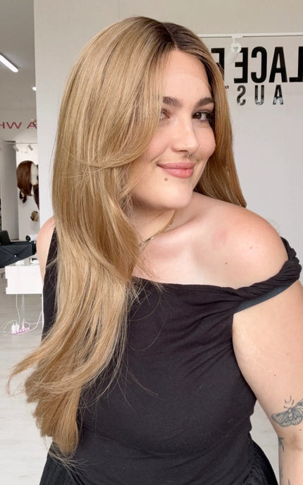 t-part lace front wig with a set middle part and glueless wig cap. long length layered honey blonde hair with shadow root and heat safe hair.