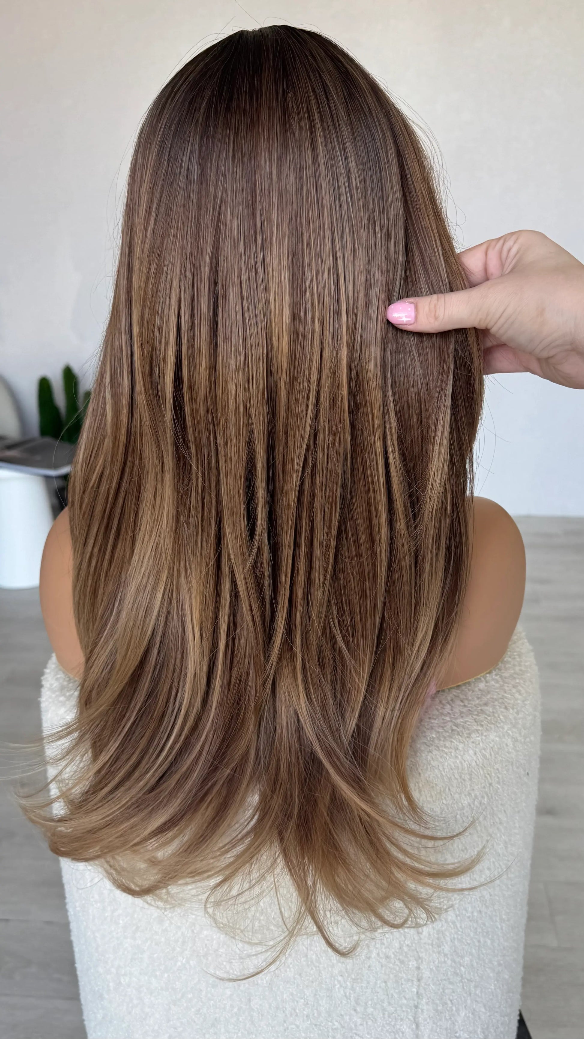layered hair ombre wig from back holding long hair.