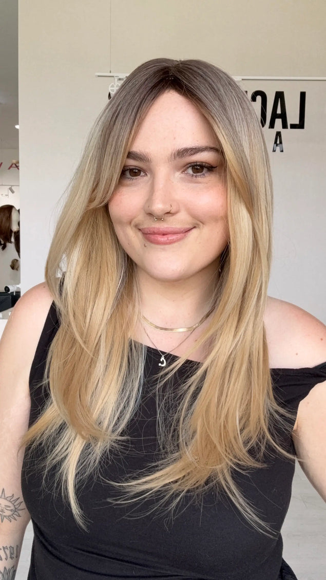 a warm vanilla blonde wig with mid-long length hair. featuring a middle part, long curtain bangs and layers throughout for movement.