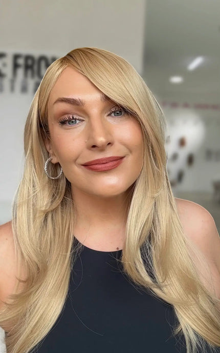 warm golden blonde hair with layers and left side part, medium to long length hair.