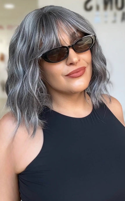 wavy ash grey bob length hair with middle part and soft wispy fringe, sitting at collarbone length.