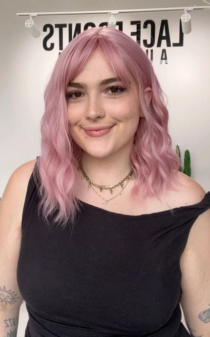 heat safe wavy pink hair synthetic wig, middle part with fringe parted to the side.