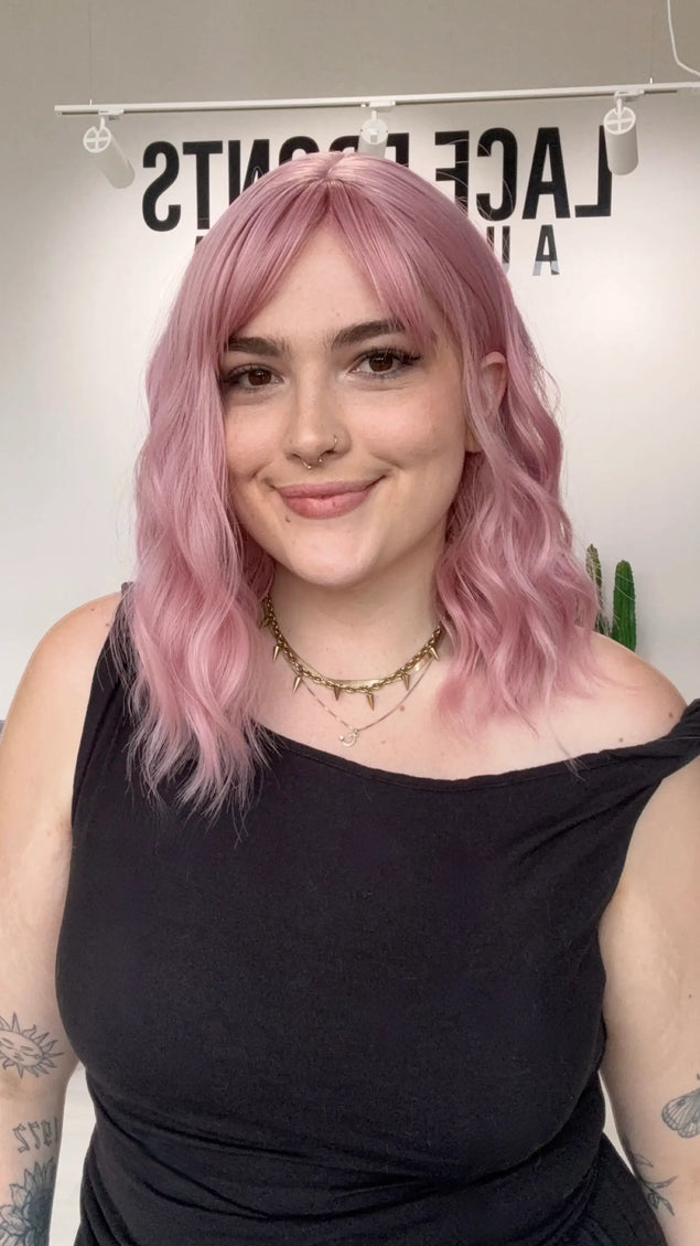 heat safe wavy pink hair synthetic wig, middle part with fringe parted to the side.