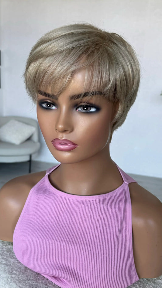 Mannequin head with a short blonde wig and pink top against a neutral background